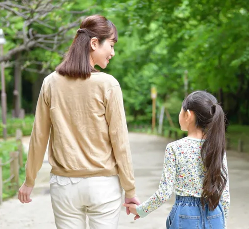 仲良く手をつなぐ母親と娘